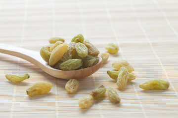 Green raisins on a wooden spoon