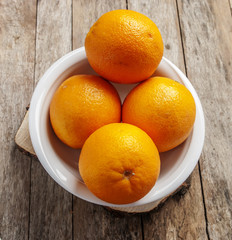 orange in white plate on wooden background