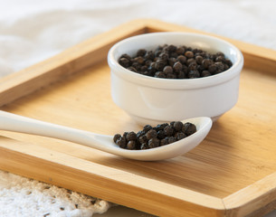 Black pepper on wood background