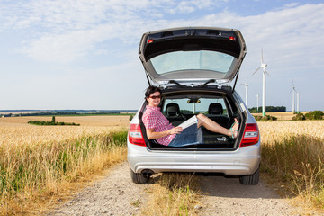Woman sitting in the trunk of her car
