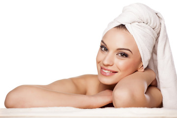 smiling beautiful girl with a towel on her head posing on white
