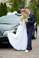 bride and groom around a decorated car
