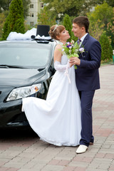 bride and groom around a decorated car
