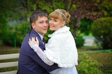 bride and groom in the park, a wedding bouquet, wedding dresses