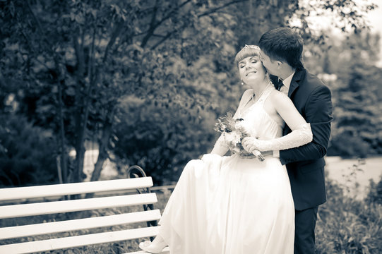 bride and groom in the park, a wedding bouquet, wedding dresses