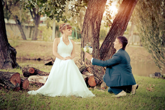 bride and groom in the park, a wedding bouquet, wedding dresses