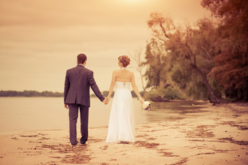 Fototapeta na wymiar bride and groom on the beach, a wedding bouquet, wedding dresses