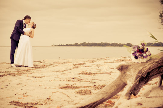 bride and groom on the beach, a wedding bouquet, wedding dresses