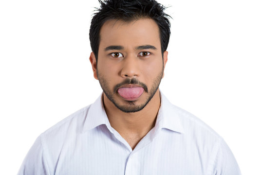 Funny, unhappy young man sticking out his tongue
