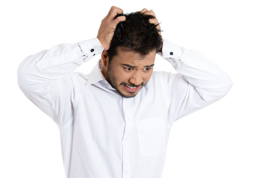 Overwhelmed young stressed man pulling out his hair