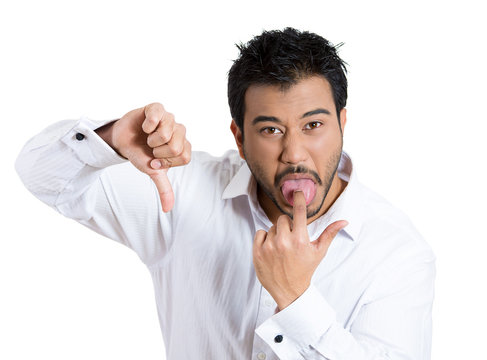 Annoyed man sticking out his tongue showing thumbs down