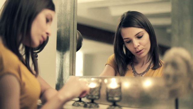 Beautiful sad, pensive woman standing by the mirror