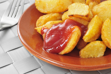 typical spanish patatas bravas, fried potatoes with a hot sauce