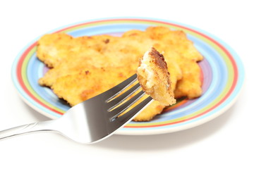 Piece of fried chicken breast on fork