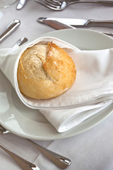 Petit pain dans une assiette sur une table dressée