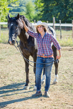Cowgirl with a Black Stallion Horse