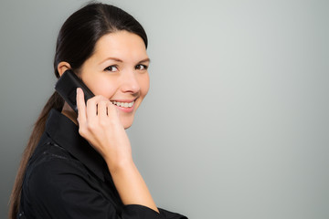 Attraktive Frau lacht an ihrem Mobiltelefon