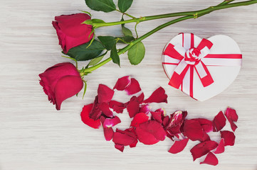 Valentine`s Day gift and roses on wooden background.
