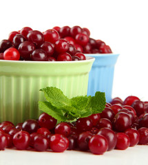 Ripe red cranberries in bowls, isolated on white.