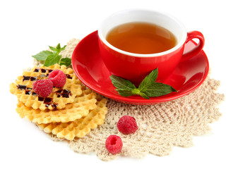 Cup of tea with cookies and raspberries isolated on white