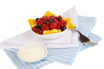Useful fruit salad of fresh fruits and berries in bowl isolated