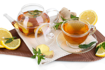 Kettle and cup of tea with ginger on napkin isolated on white