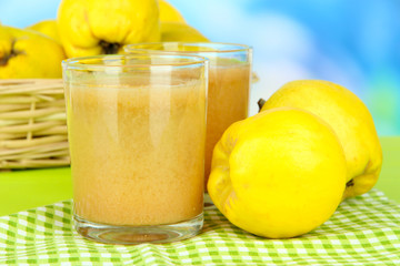 Sweet quince with juice on table on light blue background