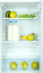 Milk bottles, vegetables and fruits in open refrigerator.