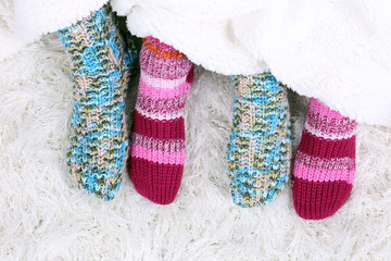 Legs in colorful socks on white carpet background