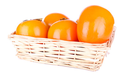 Ripe persimmons in wicker basket isolated on white