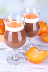 Dessert of chocolate and persimmon on table on light background
