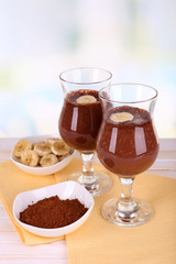 Cocktails with banana and chocolate on table on light