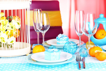 Table serving with colorful tableware on room background