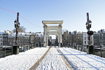 Naklejka premium Snowy thiny bridge in Amsterdam the Netherlands in winter