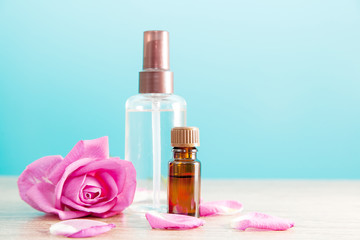 Fototapeta na wymiar Butelka z aromatycznego olejku różanego i różowym