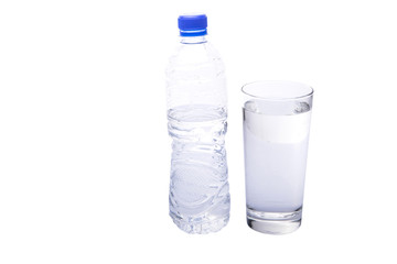 Water filled glass with mineral water bottle