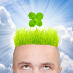A man with four leaf clover on green hair.