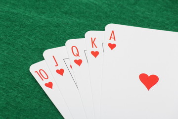 Poker cards with royal flush combination on green table