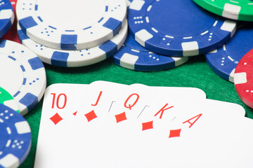 royal flush combination at poker with chips on the green table