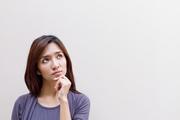 thinking woman, facing upward on plain background