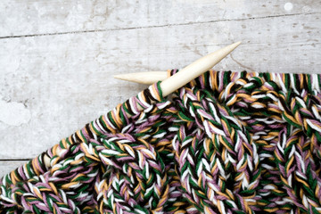 Knitting needles and yarn on wooden background