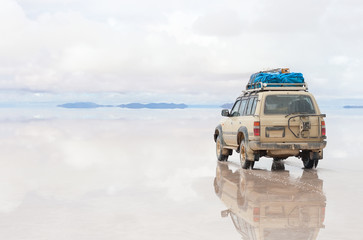 Car moving on Salar de Uyuni lake in Bolivia