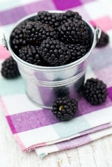 blackberries in a bucket on kitchen towel