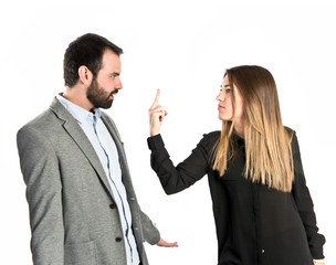 Girl doing the horn sign at her boyfriend over white background