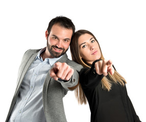 Couple pointing to the front over white background