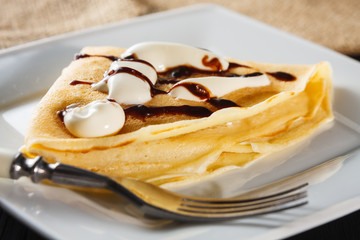 crepe with whipped cream and chocolate sauce