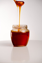 glass of fresh honey on white background