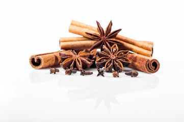Cinnamon, anise and cloves on white background