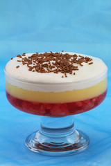 Strawberry trifle on blue background with copy space