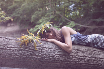 Young beautiful woman laying on the tree